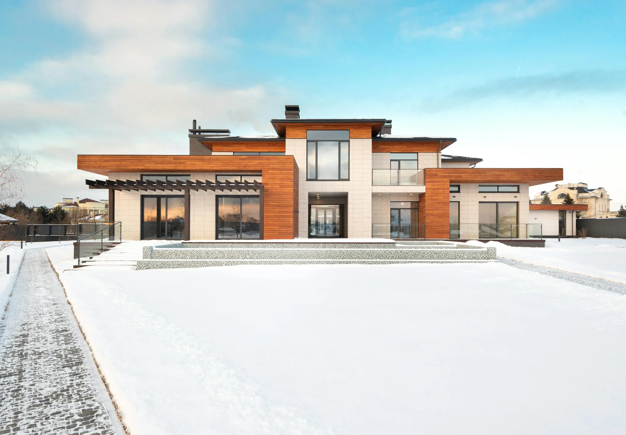 Home Contemporary house with wooden facade in snowy landscape, ideal for winter real estate.